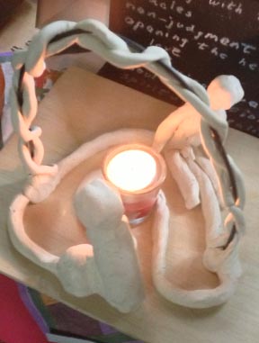 Sculpture with lighted candle